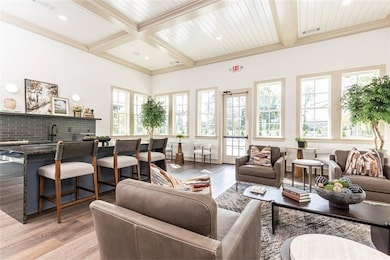 Living room featuring beamed ceiling, light hardwo