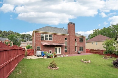Rear view of property featuring a gate, a chimney,