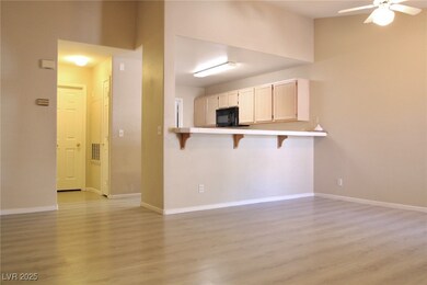 Kitchen featuring baseboards, a breakfast bar, lig