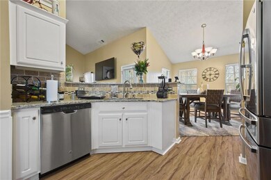 Kitchen featuring a peninsula, a sink, vaulted cei