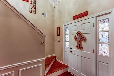 Beautiful entry with hardwood floors, staircase to