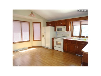 Kitchen with laminate floors, appliances, bayed ea