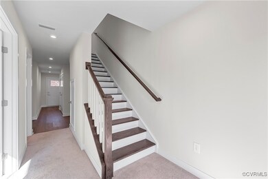 Stairway with carpet floors, recessed lighting, ba