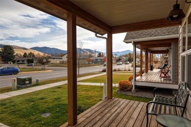 Deck with a mountain view, a porch, and a yard