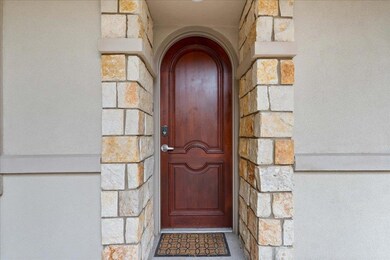 Entrance to property featuring stone siding