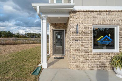 View of exterior entry with brick siding and a yard