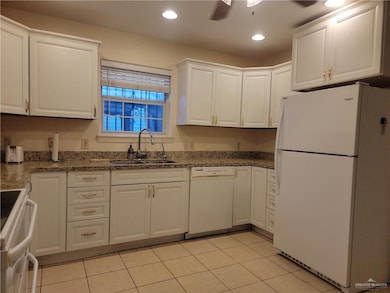 Kitchen with white appliances, white cabinets, light tile patterned floors, recessed lighting, and ceiling fan