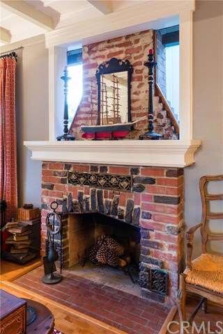 Original brick fireplace in living room.  Windows 