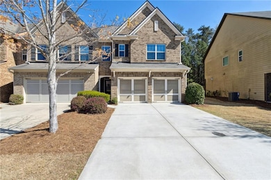View of front of property featuring brick siding, concrete driveway, central air condition unit, and an attached garage
