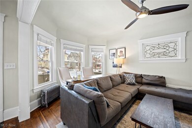 Living room featuring radiator, dark wood-type flooring, and ceiling fan