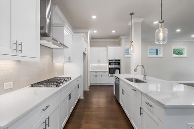 GE Stainless Steel appliances include range hood, gas stove top, microwave/oven combo and dishwasher.