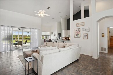 Family room with high ceilings and open space leads out to pool lanai. 