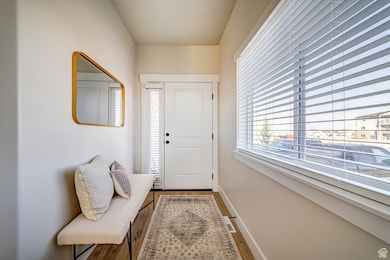 Doorway with baseboards and wood finished floors