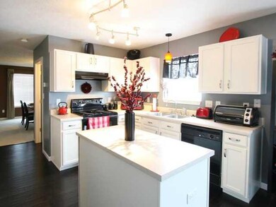 Kitchen. Beautiful white cabinets look crisp against these ebony floors! The island provides extra room for food preparation!