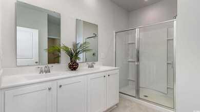 Bathroom with walk in shower, vanity, and tile pat