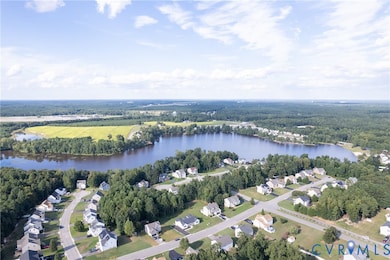 Aerial view of property and surrounding area featuring a nearby body of water and nearby suburban area