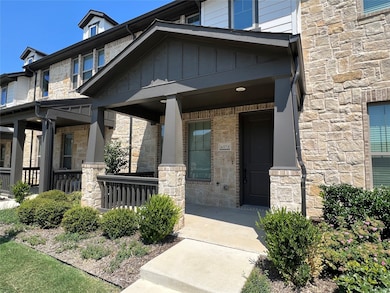 Entrance to property featuring stone siding, a porch, and board and batten siding