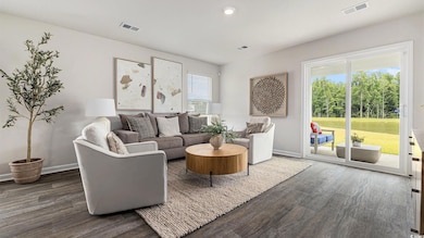 Living area with dark wood-style floors, healthy amount of natural light, and recessed lighting