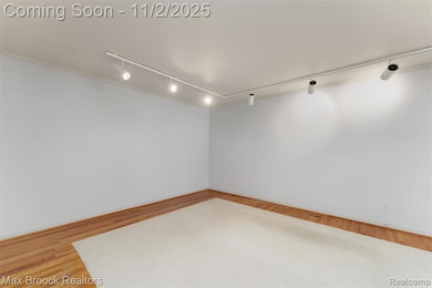 Living room with  rail lighting and light wood finished floors