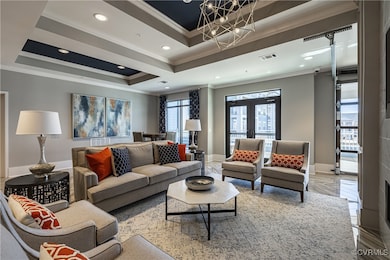 Living room featuring a tray ceiling, ornamental m