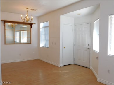 Foyer entrance with a chandelier and light wood fi