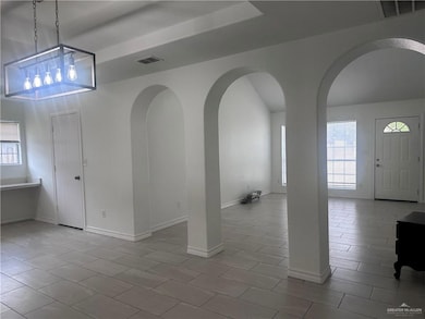 Tiled foyer featuring arched walkways and baseboards