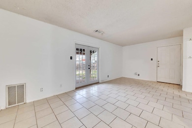 Spare room featuring french doors and a textured 