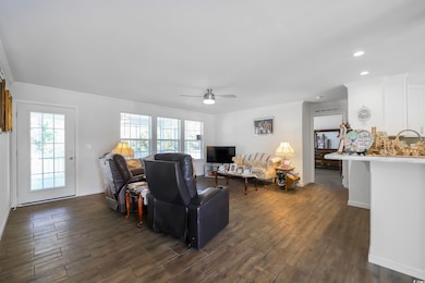 Living room with dark wood-style floors, ceiling fan, and recessed lighting