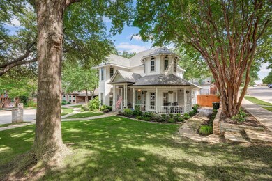 View of front side of property featuring a covered wrap-around porch and tiered side yard