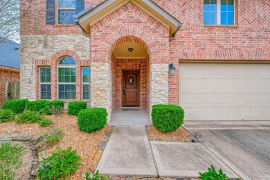 Brick and Stone elevation with mature trees and manicured landscaping