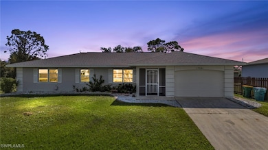 Single story home featuring a yard and a garage