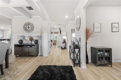 Foyer featuring light wood-type flooring, beamed ceiling, crown molding, and recessed lighting