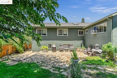 Rear view of house with a patio and roof with shingles