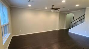 Unfurnished room featuring arched walkways, crown
