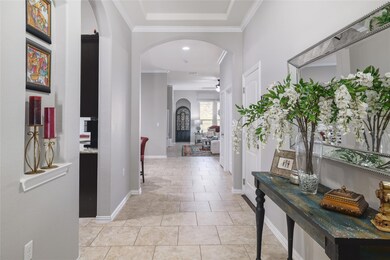 Hallway with arched walkways, baseboards, and orn