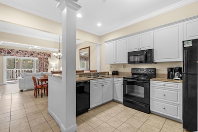 Kitchen with sink, black appliances, light tile pa