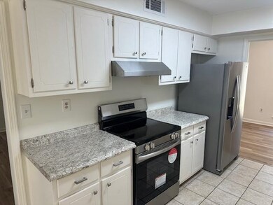 Kitchen featuring white cabinets, stainless steel 