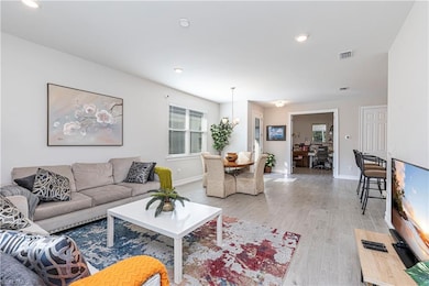 Living room featuring light wood-style floors, bas