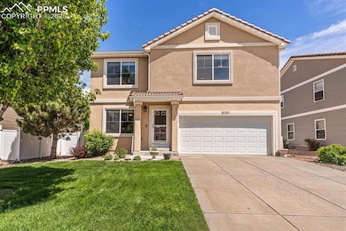 Traditional-style house featuring a garage, stucco siding, driveway, and a tiled roof