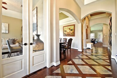 Look at the detail that this home has! Arched Doorways, Art-Niche with Recessed Light, Upgraded Gorgeous Wood Floors, Accent Paint, Rounded Corners and more!  Simple Stunning! Grand Entry with Dramatic High Coffered Ceilings and more!  Move in ready and looks like a Model!