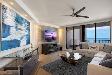 Living area featuring wood finished floors, ceiling fan, a wall of windows, and recessed lighting