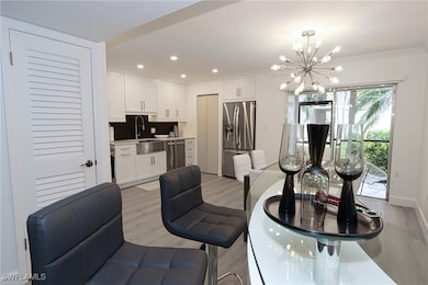 Dining room featuring a chandelier, light wood-style flooring, crown molding, and recessed lighting