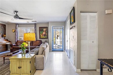 Living area featuring a ceiling fan and light tile patterned floors