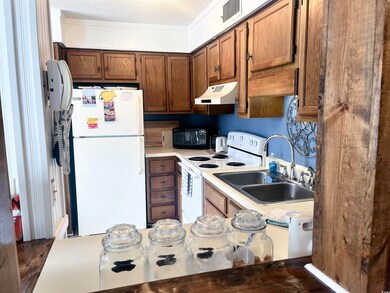 Kitchen with sink, a textured ceiling, dark hardwo