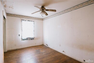 Empty room with dark wood-type flooring and ceiling fan