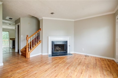 Unfurnished living room featuring baseboards, stai