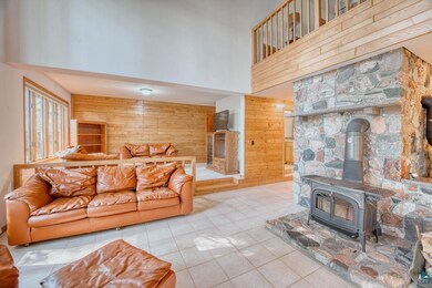 Tiled living room featuring a wood stove, wood wal