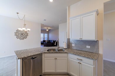 Kitchen featuring a peninsula, light stone counte