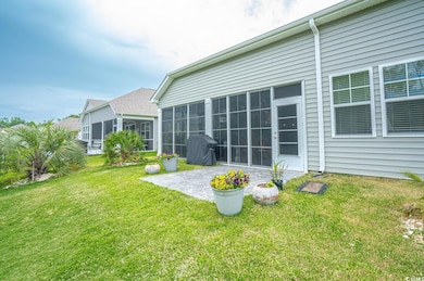 Back of property with a patio, a lawn, and a sunro
