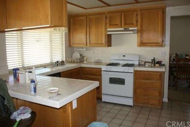 Kitchen with vinyl floors and white appliances. Pu